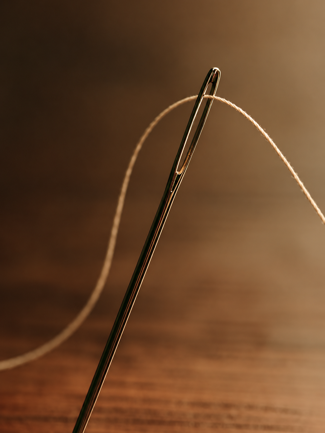 Needle with beige thread in warm light