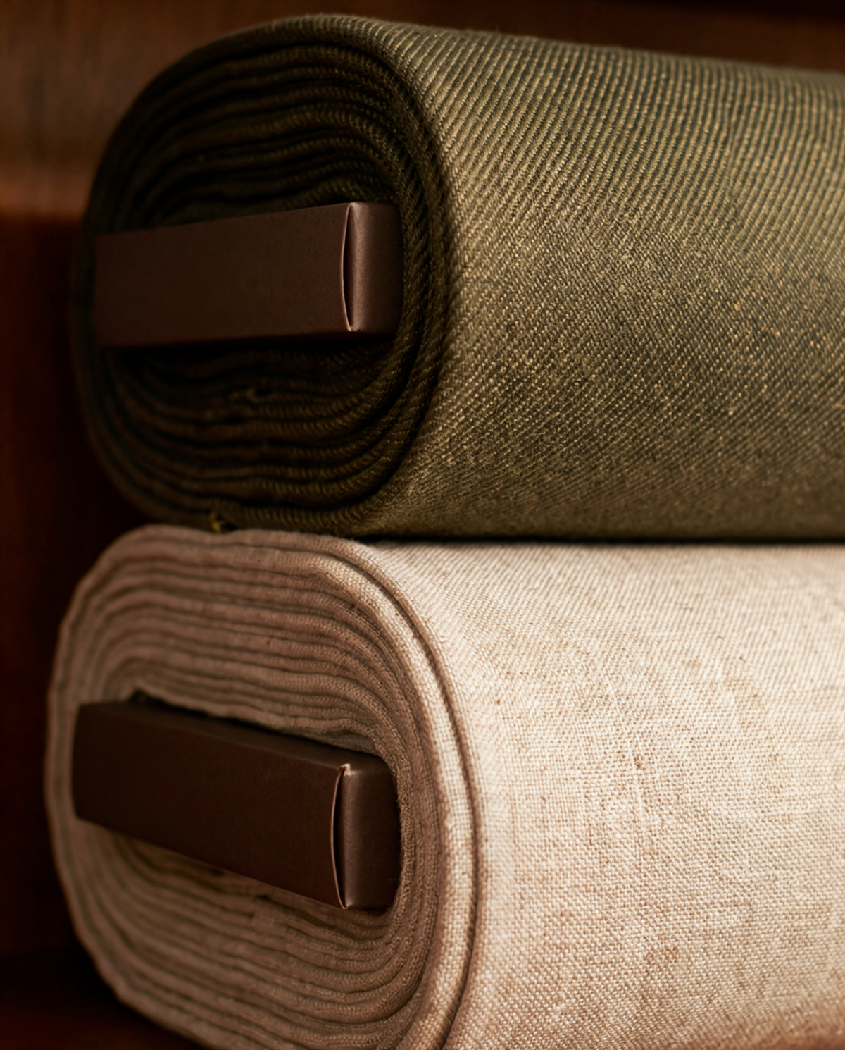 Close-up of rolled Linea fabric in sand and olive tones