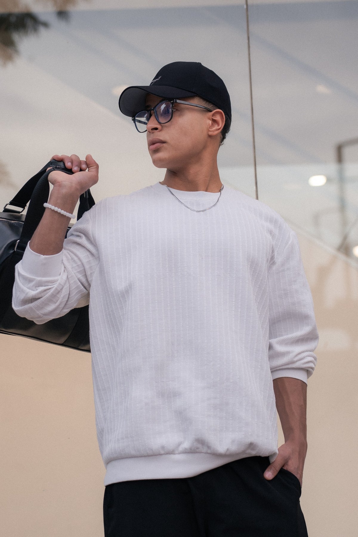 Model wearing a dark Forma cap against a light architectural background